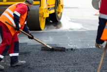The road workers' working group updates part of the road with fresh hot asphalt and smoothes it for repair.