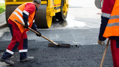 The road workers' working group updates part of the road with fresh hot asphalt and smoothes it for repair.