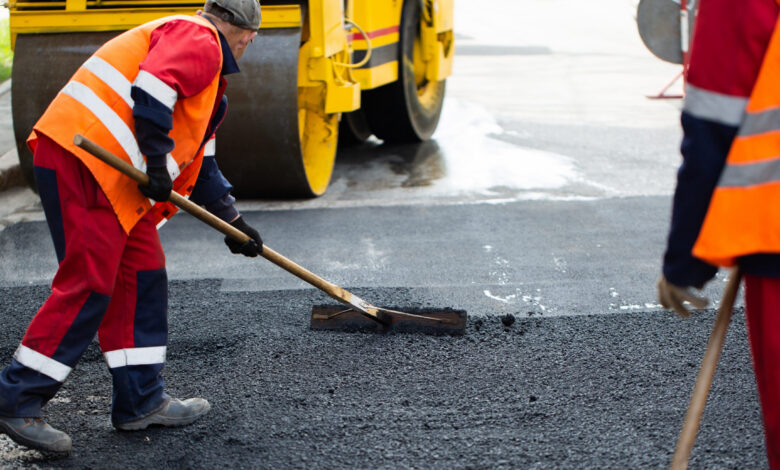 The road workers' working group updates part of the road with fresh hot asphalt and smoothes it for repair.